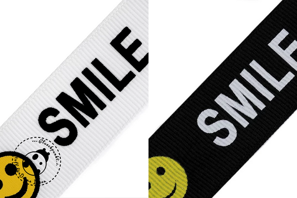 Ripsband "Big Smile". Streifen-Dessin mit dem Schriftzug "Smile" in weiß auf schwarzem Hintergrund oder schwarz auf weißem Hintergrund.Band ist weich, aber trotzdem sehr stabil und fest. Angenehm im Griff. Unelastisch.  Unser Tipp: Im Moment ist es sehr angesagt, sich diese Bänder seitlich an Jacken, Röcken oder Hosen zu Nähen. Webband wird zum Verzieren von Bekleidung, Taschen, etc. verwendet, allerdings kann es auch zur Erstellung von Etiketten genutzt werden. Web-Band, Rips-Band - Glückpunkt.