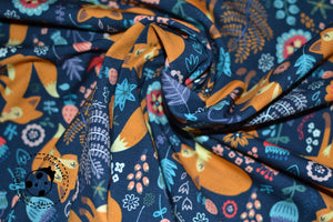 Jersey "Fuchs mit Blumen". Tierisches Dessin mit Füchsen und Blumen auf dunkelblauem Hintergrund. Jersey eignet sich besonders gut für die Herstellung von Kleidungsstücken, wie z.B. Jacken, Kleidern, Röcken, T-Shirts, Mützen etc. Nähen - Mädchen/Damen/Baby - Meterware - Glückpunkt