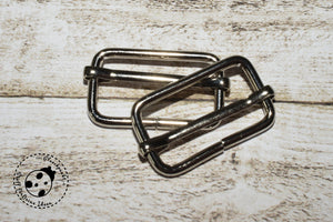 Gurtschieber-Set "Metall" - 2 Stück. Der Gurt-Schieber ist in der Verbindungsstelle nicht verschweißt. Für Gurtband in Breite 25 mm. Gurtschieber eignen sich besonders zum Befestigen von Gurten an Taschen oder Handtaschen, sowie für die Herstellung von Hundeleinen oder Schnullerbändern. Gurtschieber, Schieber, Gurt-Schieber - Nähen für Taschen & Täschchen - Glückpunkt